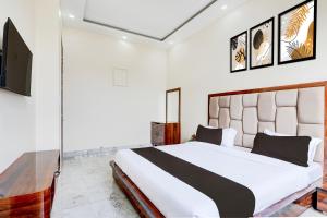 a bedroom with a large bed and a tv at Hotel O BAL GOPAL in Delhi