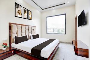 a bedroom with a large bed and a television at Hotel O BAL GOPAL in Delhi +19 photos