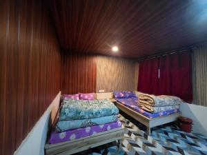 a room with two beds and a table in it at BBASAN FARMs in Darjeeling