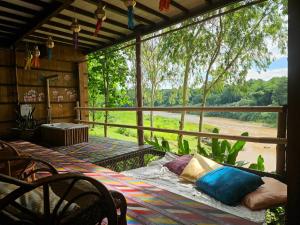 a screened in porch with a view of a field at Nan De Panna Homestay in Nan