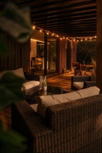 a patio with wicker furniture and lights on a deck at Ô Temps Des Pins in Éguilles