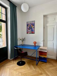 a blue desk in a room with a chair at Bauhaus Suite Dessau in Dessau