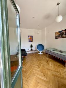 a living room with a couch and a wooden floor at Bauhaus Suite Dessau in Dessau