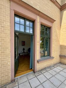 an open door in a brick building with a wooden floor at Bauhaus Suite Dessau in Dessau