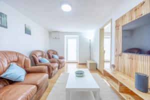 a living room with leather furniture and a table at Casa da Floresta in Machico