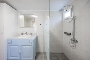 a white bathroom with a sink and a shower at Casa da Floresta in Machico +53 photos