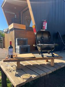 a grill sitting on top of a wooden table at Viento Sur Pichilemu Tiny House con Mini Parrilla y opción de Hot Tub in Pichilemu