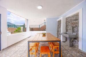 a dining room with a wooden table and chairs at Casa da Floresta in Machico