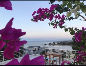 a view of the ocean from a table and flowers at Begonvil Otel in Emin Sitesi +2 photos