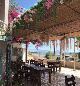 a patio with wooden tables and chairs and flowers at Begonvil Otel in Emin Sitesi