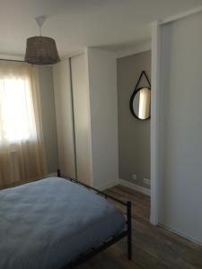 a bedroom with a bed and a mirror on the wall at Chez lydie et jeff in Laudun