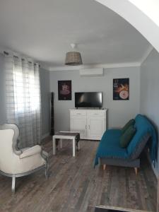 a living room with a couch and a tv at Chez lydie et jeff in Laudun