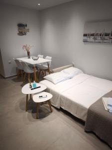 a bedroom with a bed and a table and a dining room at Minimal Apartments Parga in Parga