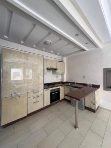 a large kitchen with a table in the middle at Mohammedia Luxury Suite in Mohammedia