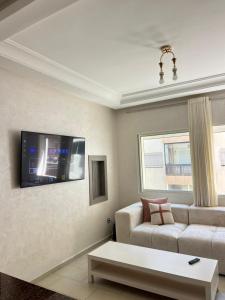 a living room with a couch and a tv at Mohammedia Luxury Suite in Mohammedia