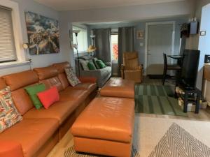 a living room with an orange leather couch and a living room at The Dune Beach House in Norfolk