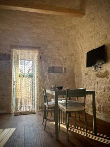a table and chairs in a room with a window at Al Settimo Chilometro in Gioia del Colle