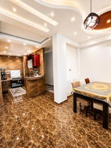a dining room with a table and a kitchen at شقة مميزة بجوار كورنيش النيل اسوان - عائلات فقط in Aswan