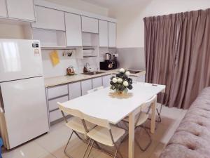 a kitchen with a table with a vase of flowers on it at Swiss Garden resort residence by Moonlight in Kuantan