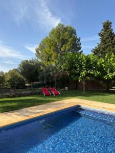 a swimming pool with two red chairs in a yard at The Pines Hotel in Culla +61 photos
