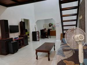 a living room with a couch and a fan at Villa GreenHill A1 SibolangitView in Bandarbaru