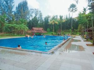 a large swimming pool with people in the water at Villa GreenHill A1 SibolangitView in Bandarbaru