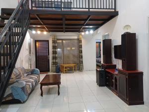 a living room with a couch and a staircase at Villa GreenHill A1 SibolangitView in Bandarbaru
