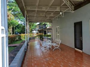 a patio with chairs and a table on a house at Villa GreenHill A1 SibolangitView in Bandarbaru