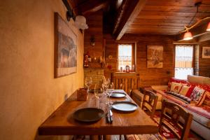 a dining room with a wooden table and a couch at Casa Lotre in Pragelato