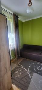a room with a bed and a green wall at Pokoje u Irenki in Augustów