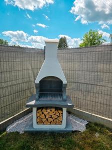 a pizza oven in a backyard with a fence at Górskie Zakątek in Kalna +1 photo