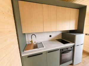 a kitchen with wooden cabinets and a sink at Górskie Zakątek in Kalna