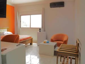 a living room with a couch and a chair at OABY'S Hôtel in Bobo-Dioulasso