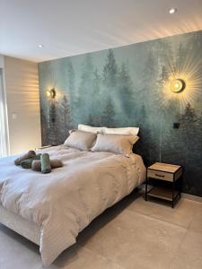 a bedroom with a large bed with a painting on the wall at La Loge des Deux Sapins in Oberbetschdorf