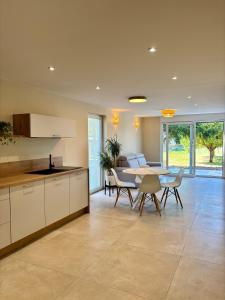 a kitchen and dining room with a table and chairs at La Loge des Deux Sapins in Oberbetschdorf