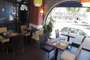 a restaurant with tables and chairs and a car at Hôtel de France in Espalion