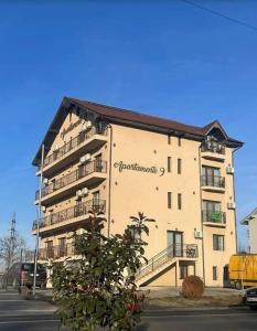 a large building with a sign on the side of it at Apartamente 9 Teo in Baile Felix