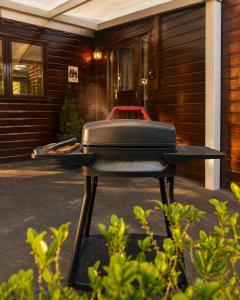 a barbecue grill sitting outside of a house at Rustiek Boschalet Sven Veluwe met Omheinde Tuin in Putten +44 photos