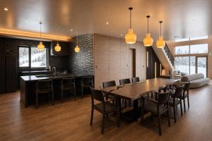 a dining room with a large wooden table and chairs at THE OneThird HAKUBA Slopefront Villas in Hakuba