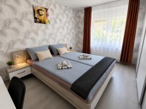 a bedroom with a bed with two towels on it at By the Center in Balatonalmádi