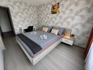 a bedroom with a large bed with blue sheets at By the Center in Balatonalmádi +4 photos