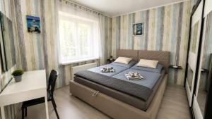a bedroom with a bed and a table and a window at By the Center in Balatonalmádi