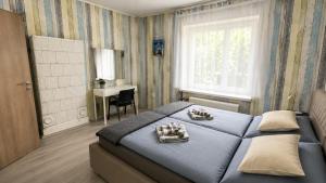 a bedroom with a blue bed and a desk at By the Center in Balatonalmádi
