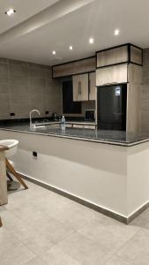 a large kitchen with a counter and a sink at Lurret Hotel in Qaryat at Ta‘mīr as Siyāḩīyah