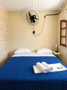 a bed with two towels and a fan on the wall at Pousada Viva Mar in Saquarema +61 photos
