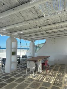a dining area with a table and chairs and the beach at Casa Mediterranea al mare, Jacuzzi, Torre Guaceto, Ostuni in Specchiolla