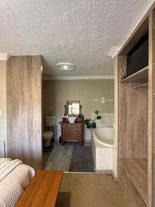 a bathroom with a bed and a tub and a sink at Zwartmodder Clarens in Clarens
