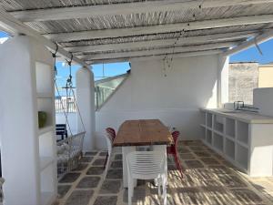 a patio with a wooden table and chairs on a roof at Casa Mediterranea al mare, Jacuzzi, Torre Guaceto, Ostuni in Specchiolla