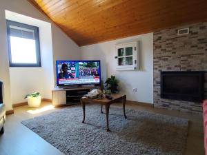 a living room with a tv and a coffee table at CASA do AÇÔR in Aldeia das Dez