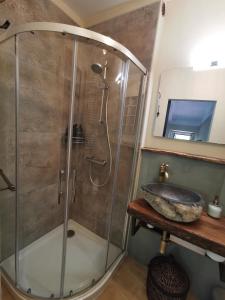 a bathroom with a glass shower with a sink at B&B Il Merlino in Chiaserna +11 photos